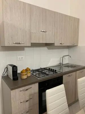 a kitchen with a stove and a sink and cabinets at Casa Katrin & Casa Brigida in Castellammare del Golfo