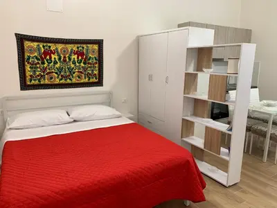 a bedroom with a bed with a red blanket at Casa Katrin & Casa Brigida in Castellammare del Golfo