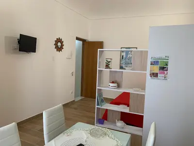 a living room with a table and a shelf at Casa Katrin & Casa Brigida in Castellammare del Golfo