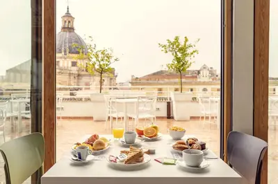 a table with breakfast food and a view of the city at B&B Hotel Palermo Quattro Canti in Palermo