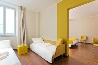 a hotel room with two beds and a mirror at B&B Hotel Palermo Quattro Canti in Palermo