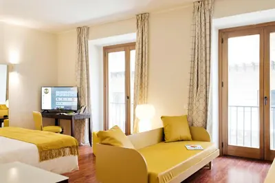 a hotel room with a bed and a couch and a television at B&B Hotel Palermo Quattro Canti in Palermo