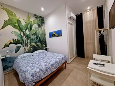 a bedroom with a bed and a plant on the wall at Numero Civico 2 in Palermo