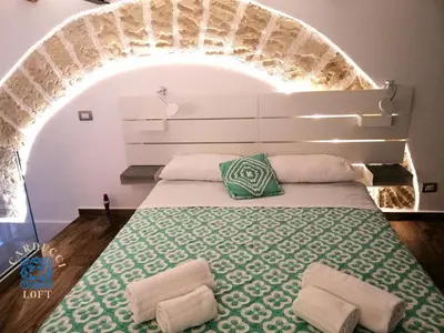 a bed with two pillows on it in a room at Carducci Loft in Castellammare del Golfo