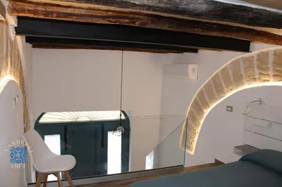 a room with a window and a chair and a mirror at Carducci Loft in Castellammare del Golfo
