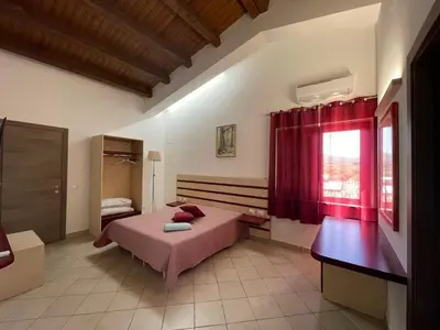a bedroom with a bed and a red curtain at Relais del sole in Partinico
