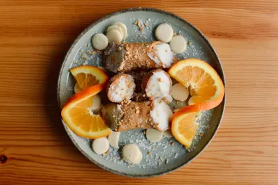a plate of food with meat and orange slices at Palermo Inn Collection - Boutique Art Hotel in Palermo