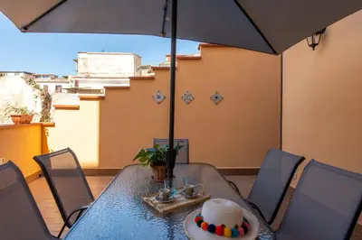 a dining table with an umbrella on a balcony at Kalsa Apartment with Terrace by Wonderful Italy in Palermo