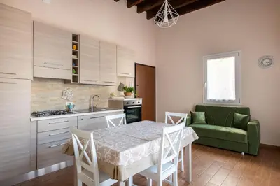 a kitchen with a table and a green couch at Kalsa Apartment with Terrace by Wonderful Italy in Palermo