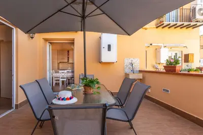 a table and chairs with an umbrella on a patio at Kalsa Apartment with Terrace by Wonderful Italy in Palermo