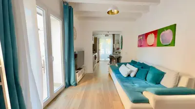 a living room with a blue couch and a large window at Merlo Holiday Room in Palermo