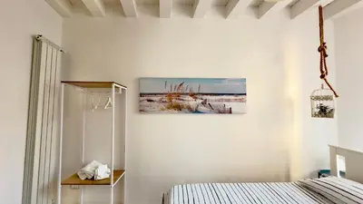 a bedroom with a bed and a painting on the wall at Merlo Holiday Room in Palermo
