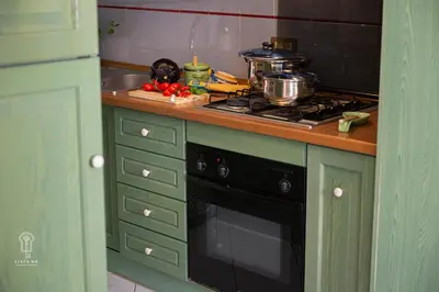 a kitchen with green cabinets and a stove top oven at CIATU ME' Scirocco in Castellammare del Golfo