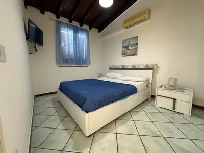 a bedroom with a bed and a television in it at AMATI HOLIDAYS in Palermo