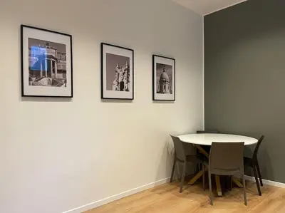 a room with a table and four pictures on a wall at Nicarè City Apartments in Palermo
