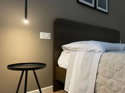 a bedroom with a bed with a table next to it at Nicarè City Apartments in Palermo