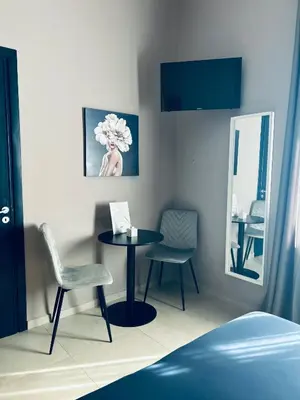 a room with a table and two chairs and a mirror at B&B Ungheria Ottantaquattro in Palermo