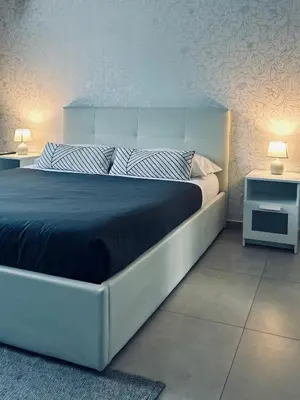 a bedroom with a large bed and two night stands at B&B Ungheria Ottantaquattro in Palermo