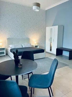 a bedroom with a bed and a table and chairs at B&B Ungheria Ottantaquattro in Palermo