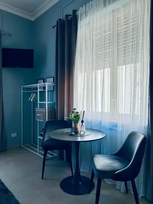 a blue room with a table and two chairs and a window at B&B Ungheria Ottantaquattro in Palermo