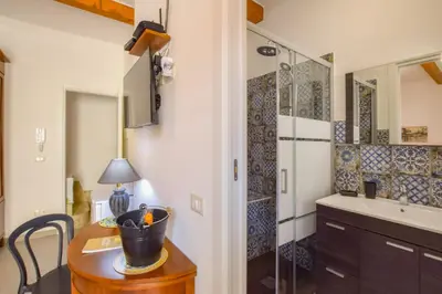 a bathroom with a table and a sink and a shower at AMUNI' Apartments in Trabia