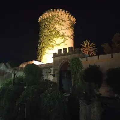 a building with a tower lit up at night at AMUNI' Apartments in Trabia
