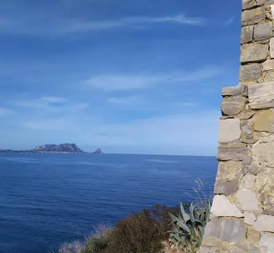 a view of the ocean from a stone building at AMUNI' Apartments in Trabia