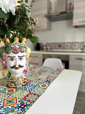 a vase with a face painted on it sitting on a table at Il melograno in Carini