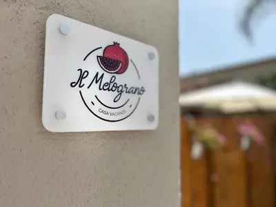 a sign on a wall with a strawberry on it at Il melograno in Carini