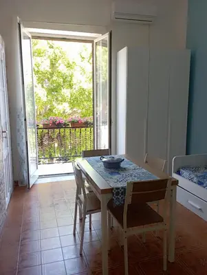 a dining room with a table and chairs and a window at Casa bluchic Gioisia in Isola delle Femmine