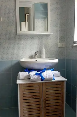 a bathroom with a sink and a counter with towels at Casa bluchic Gioisia in Isola delle Femmine