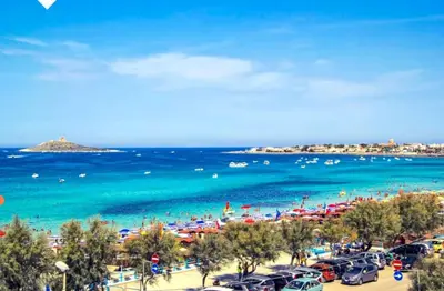 a beach with a lot of people and the ocean at Casa bluchic Gioisia in Isola delle Femmine