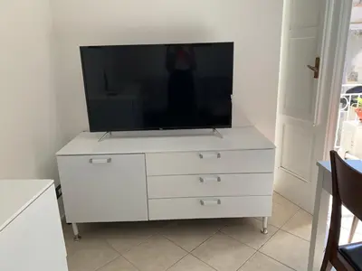 a white dresser with a television on top of it at Casavacanze Alba in Alcamo
