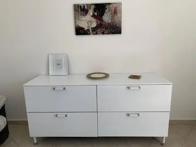 a white dresser with a clock on top of it at Casavacanze Alba in Alcamo