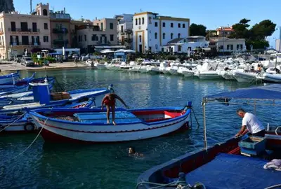 two men are on a boat in the water at Belvedere in Palermo