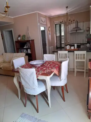 a table and chairs in a living room with a table and a kitchen at Belvedere in Palermo