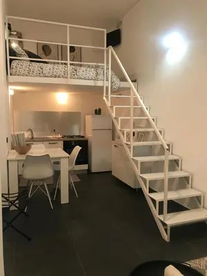 a white staircase in a room with a table and a kitchen at EDU' in Alcamo