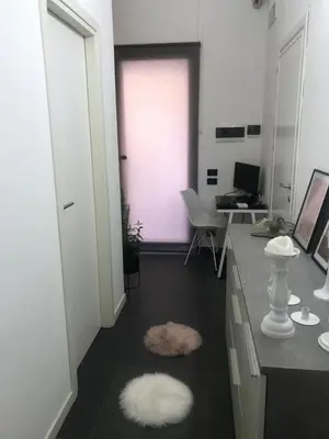 a room with a desk with two white rugs on the floor at EDU' in Alcamo