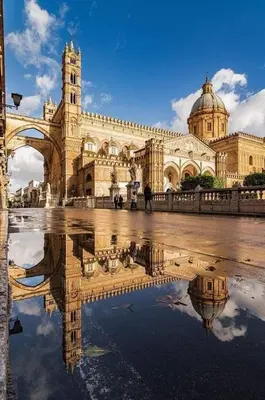 a large building with a reflection in the water at toty alla guilla in Palermo