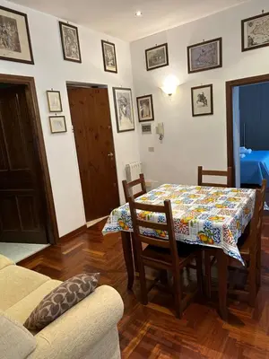 a dining room with a table and chairs and a room with a couch at toty alla guilla in Palermo