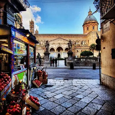 a large building with a fruit stand in front of it at toty alla guilla in Palermo
