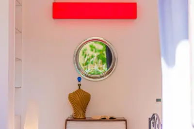 a mirror on a wall with a vase on a table at Art House Arenella con Terrazze by Wonderful Italy in Palermo