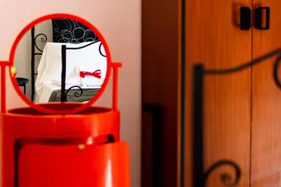 a mirror on a red chair in a bedroom at Art House Arenella con Terrazze by Wonderful Italy in Palermo