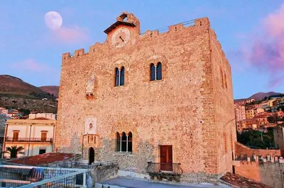a large brick building with a moon in the sky at Casa di Lia in Montelepre