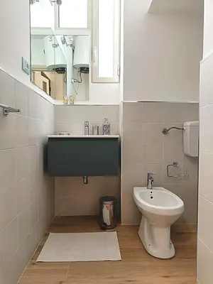 a bathroom with a sink and a toilet and a mirror at Casa Cavour in Palermo