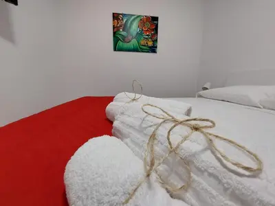 a bed with white towels and a painting on the wall at Al cortiletto in Castellammare del Golfo