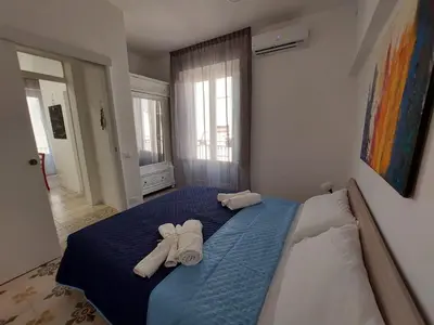 a bedroom with a blue bed with towels on it at Al cortiletto in Castellammare del Golfo