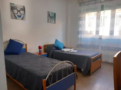 a bedroom with two beds and a window at Silvia's House in Palermo