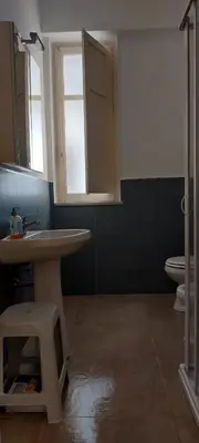 a bathroom with a sink and a toilet and a window at Silvia's House in Palermo