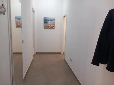 a hallway with a mirror and white walls and a hallway with a door at Silvia's House in Palermo